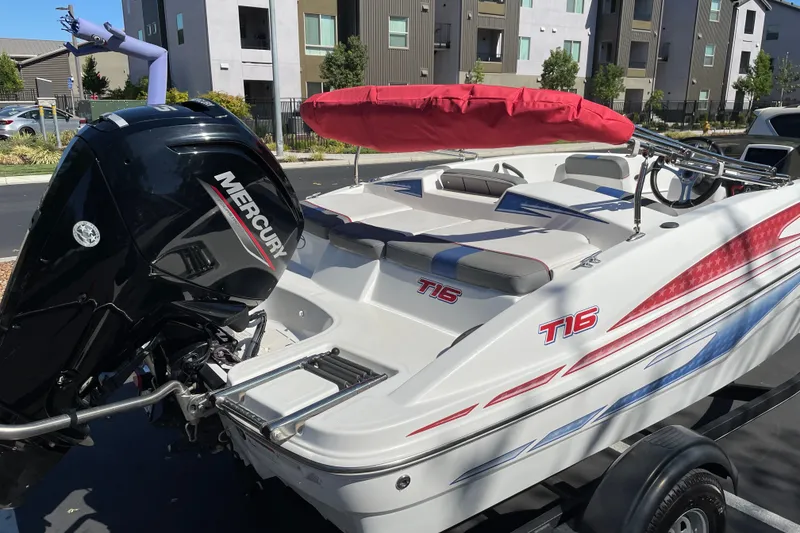 Slide: The Image of 2024 Tahoe T16 boat with Mercury engine, parked near modern apartments. - 3