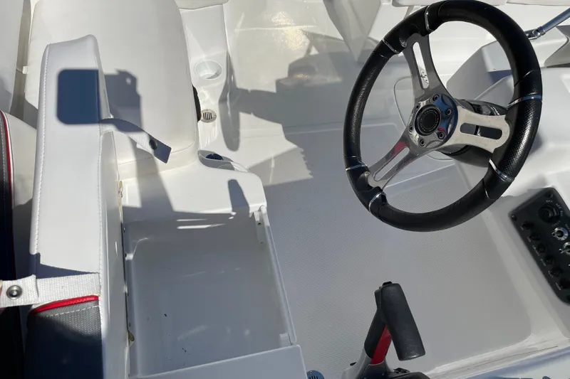 Slide: The Image of Interior of a 2024 Tahoe T16 boat featuring steering wheel and seating area. - 15