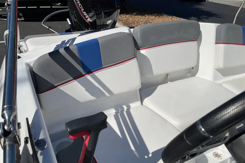 Slide: The Image of 2024 Tahoe T16 boat interior with white and gray seating, featuring red and blue accents. - 12