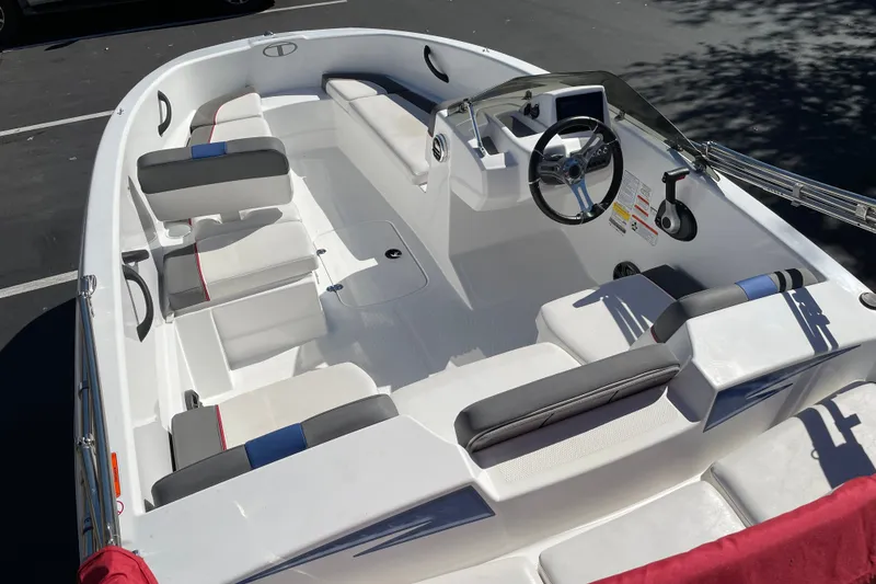 Slide: The Image of 2024 Tahoe T16 boat interior with white and gray seating, steering wheel, and dashboard. - 5