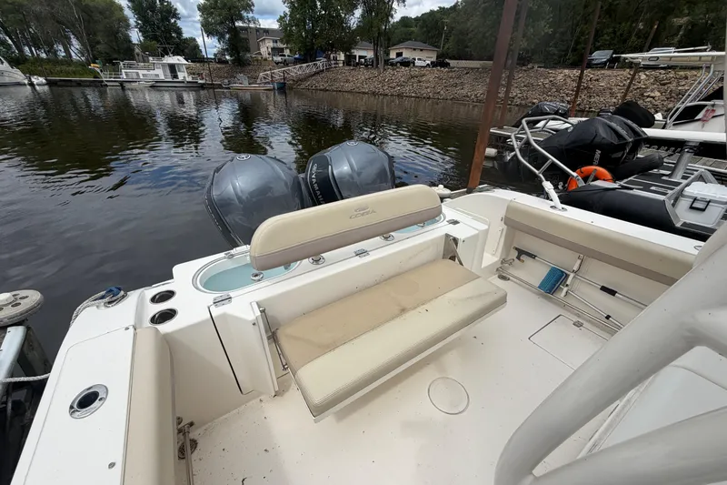 Slide: The Image of 2017 Cobia 296 Center Console boat with dual engines docked at a marina. - 17