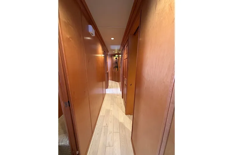 Slide: The Image of Narrow wooden hallway inside a 2003 Sumerset 18x86 houseboat, featuring warm lighting. - 6