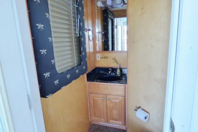 Slide: The Image of Bathroom interior of 2003 Sumerset 18x86 houseboat with wooden cabinetry and dragonfly wallpaper. - 19