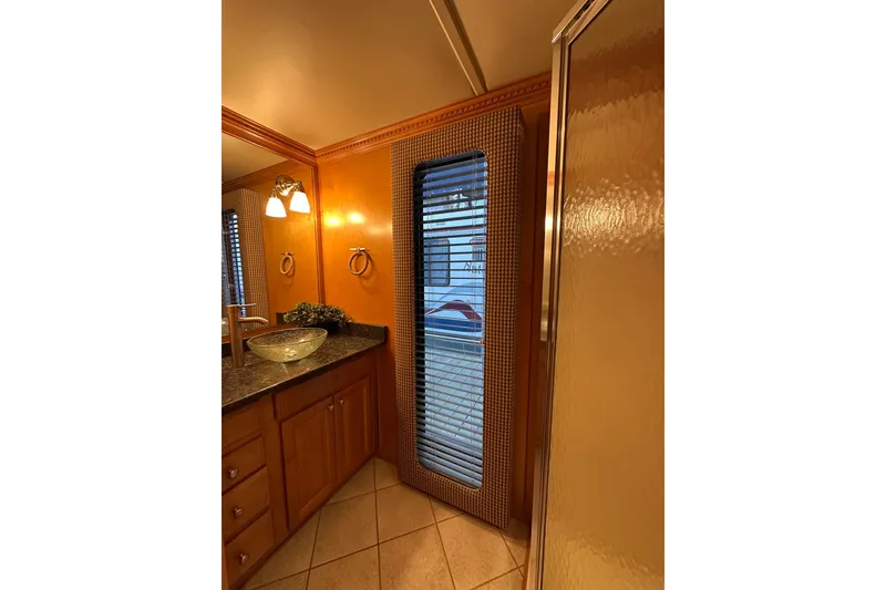 Slide: The Image of Luxurious bathroom interior of 2003 Sumerset 18x86 houseboat with elegant fixtures and wood cabinetry. - 12