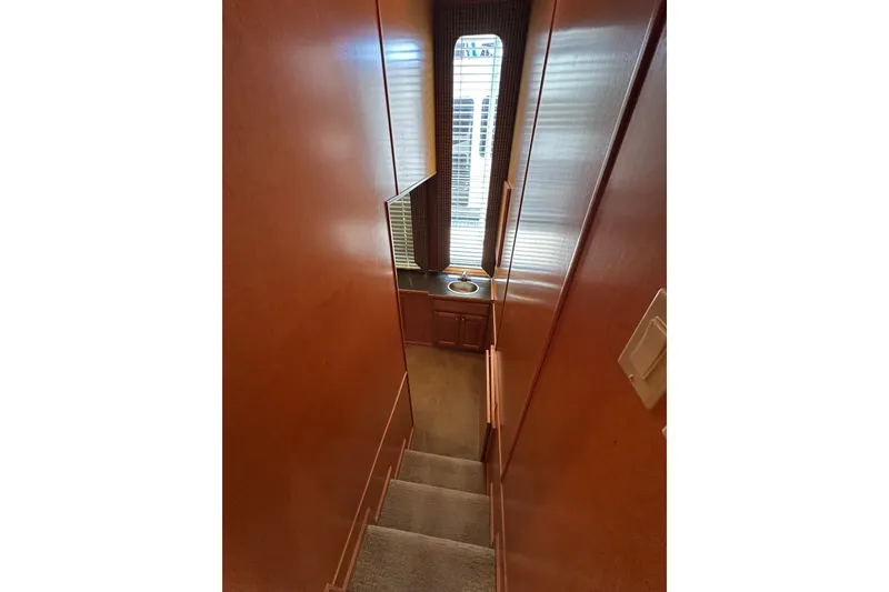 Slide: The Image of Narrow staircase in 2003 Sumerset 18x86 houseboat with wooden walls and window. - 9