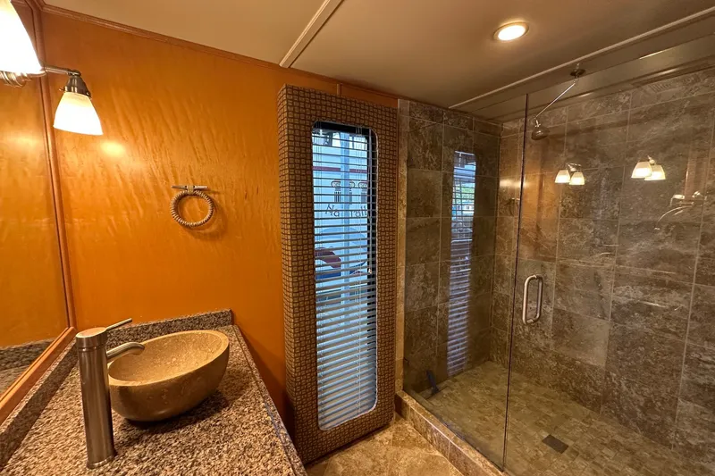 Slide: The Image of Luxurious bathroom in 2003 Sumerset 18x86 houseboat with stone sink and glass shower. - 16