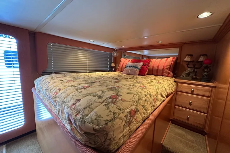 Slide: The Image of Cozy bedroom interior in a 2003 Sumerset 18x86 houseboat with floral bedding and wooden furnishings. - 7