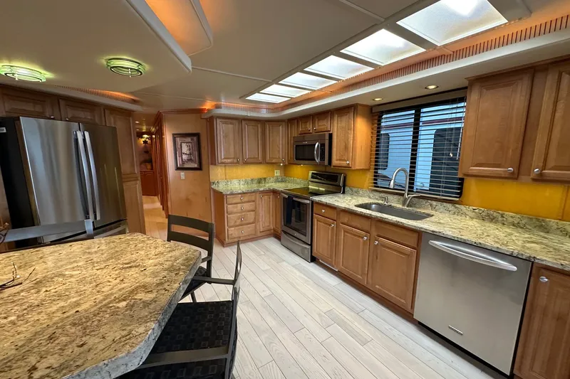 Slide: The Image of Luxurious kitchen in a 2003 Sumerset 18x86 houseboat with granite countertops and modern appliances. - 4