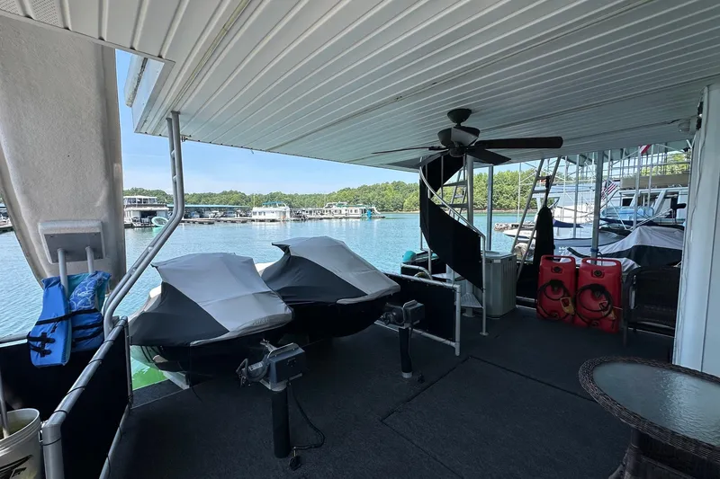 Slide: The Image of Covered deck of a 2003 Sumerset 18x86 houseboat with jet skis and lake view. - 18