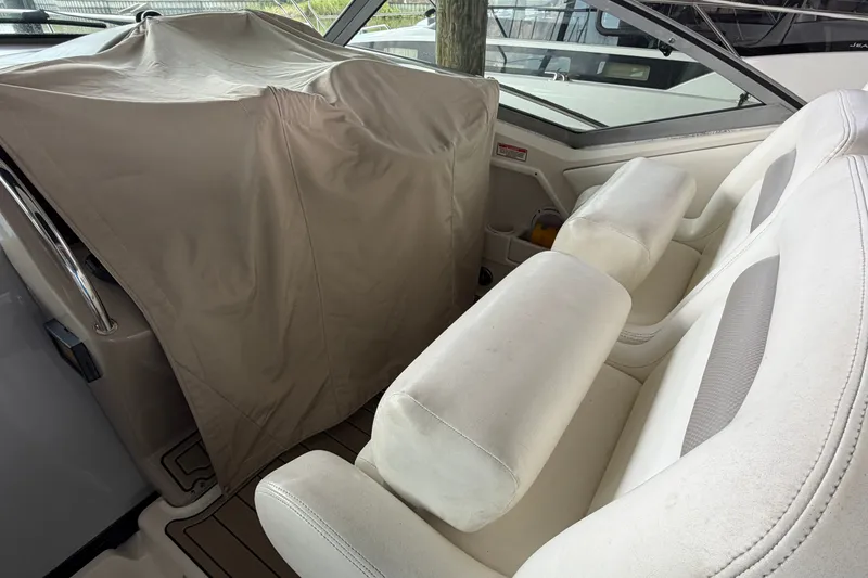 Slide: The Image of Interior of a 2004 Sea Ray Sundancer 320 with covered controls and white seating. - 30