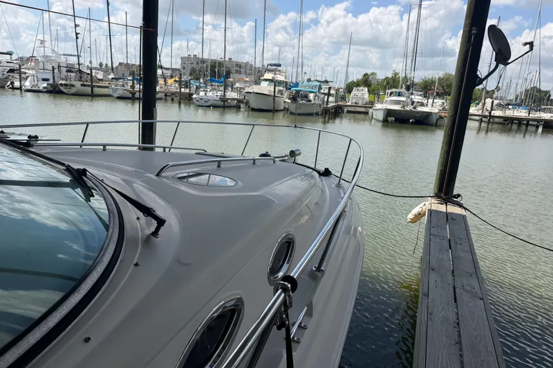 Slide: The Image of 2004 Sea Ray Sundancer 320 docked at marina with sailboats in background. - 23