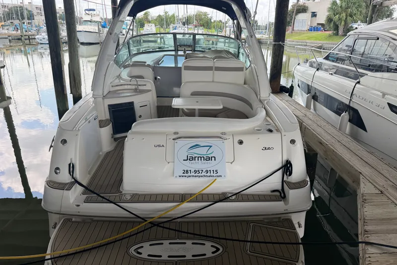 Slide: The Image of 2004 Sea Ray Sundancer 320 docked at marina, showcasing spacious seating and elegant design. - 24
