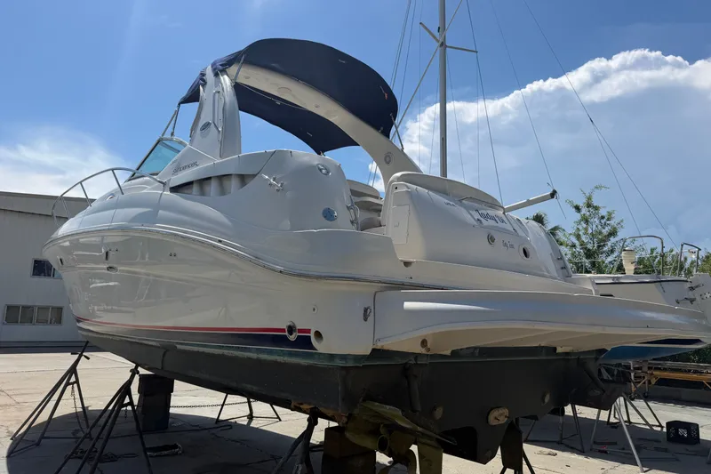 Slide: The Image of 2004 Sea Ray Sundancer 320 yacht on stands, viewed from the rear under a clear sky. - 6