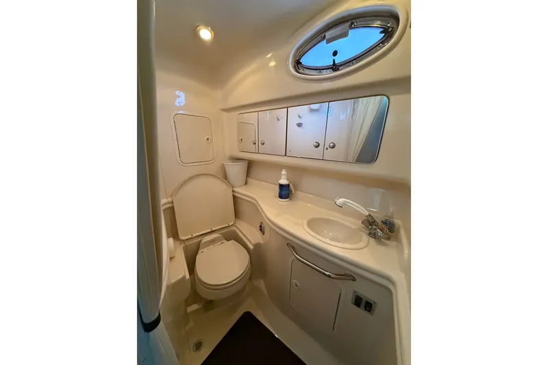 Slide: The Image of Bathroom interior of 2004 Sea Ray Sundancer 320 yacht, featuring toilet, sink, and storage. - 44