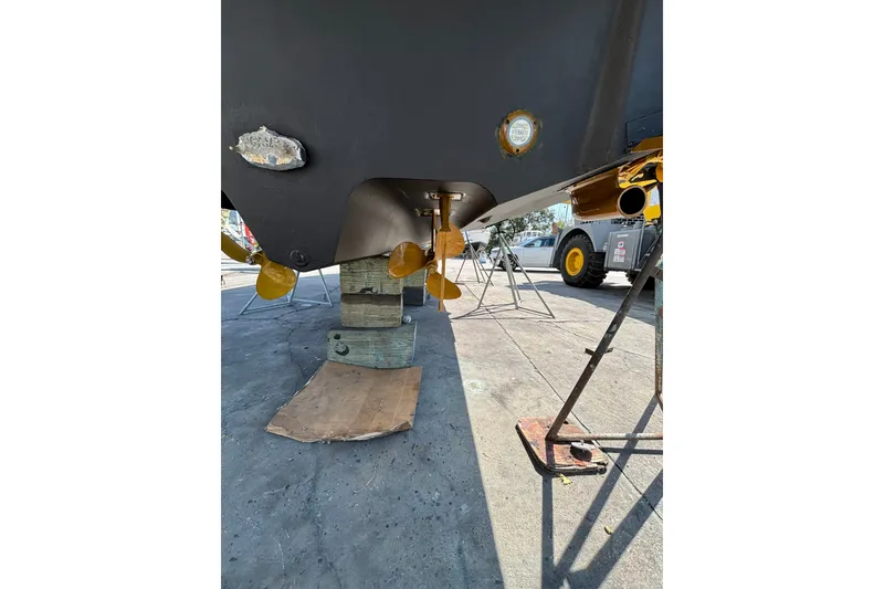 Slide: The Image of 2004 Sea Ray Sundancer 320 boat under maintenance, showing propellers and hull details. - 13