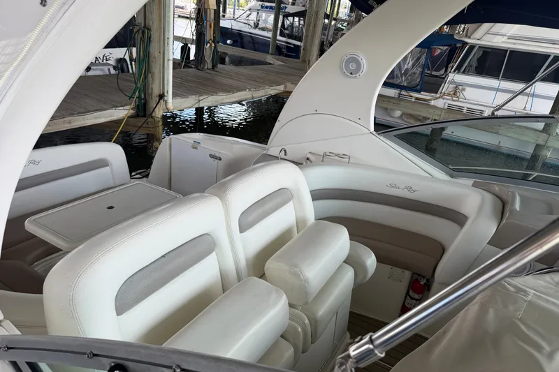 Slide: The Image of 2004 Sea Ray Sundancer 320 interior with white seating and table, docked at marina. - 22