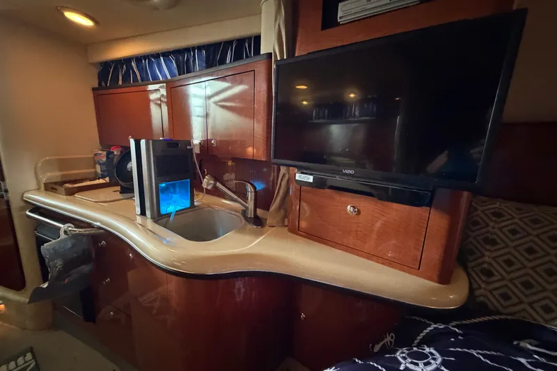 Slide: The Image of 2004 Sea Ray Sundancer 320 interior with kitchenette and mounted TV. - 48