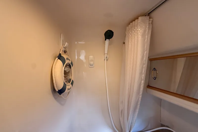 Slide: The Image of Interior of 2000 Larson Cabrio 330 boat bathroom with shower and life preserver. - 51