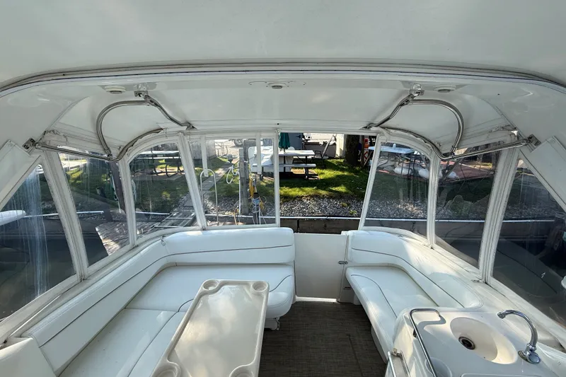 Slide: The Image of Interior of a 2000 Larson Cabrio 330 boat with white seating and a small sink. - 20