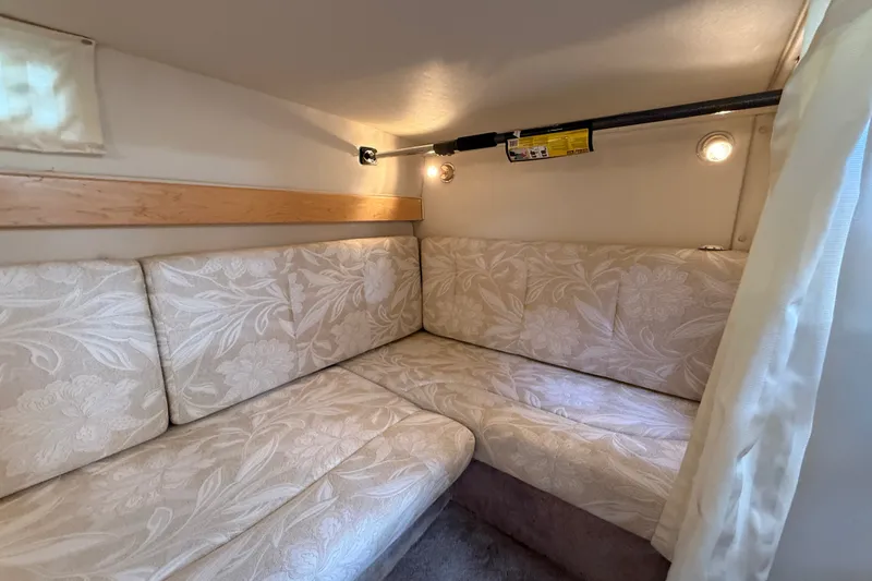 Slide: The Image of Interior cabin of 2000 Larson Cabrio 330 with floral-patterned seating and soft lighting. - 46