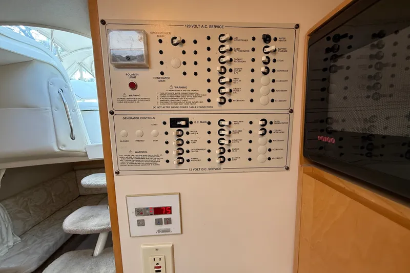 Slide: The Image of Control panel of a 2000 Larson Cabrio 330 boat, featuring electrical service switches. - 40