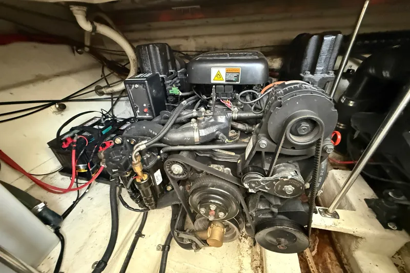 Slide: The Image of Engine compartment of a 2000 Larson Cabrio 330 boat, showcasing mechanical components and wiring. - 58