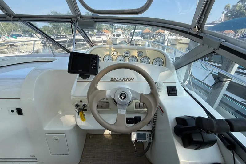 Slide: The Image of Cockpit view of a 2000 Larson Cabrio 330 boat with steering wheel and gauges. - 22