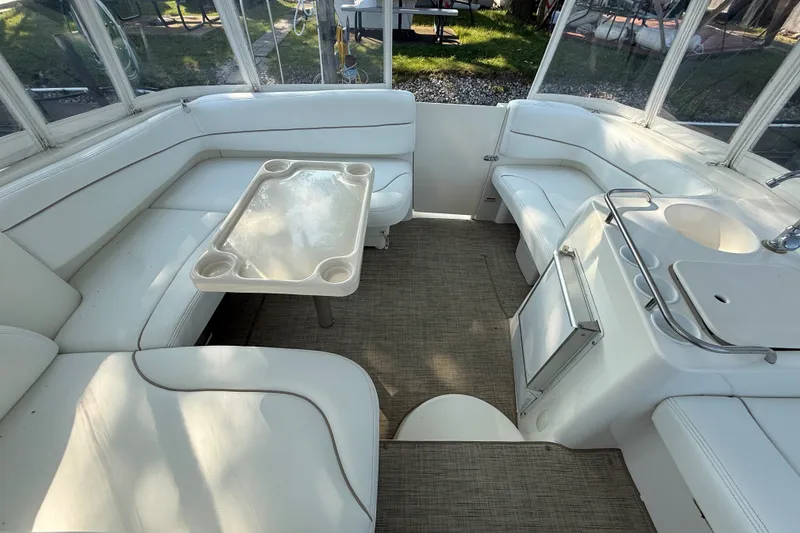 Slide: The Image of Interior of 2000 Larson Cabrio 330 boat with white seating and table. - 19