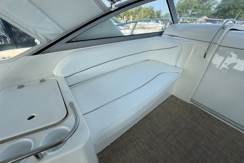Slide: The Image of Interior seating of 2000 Larson Cabrio 330 boat with white upholstery and cup holders. - 17