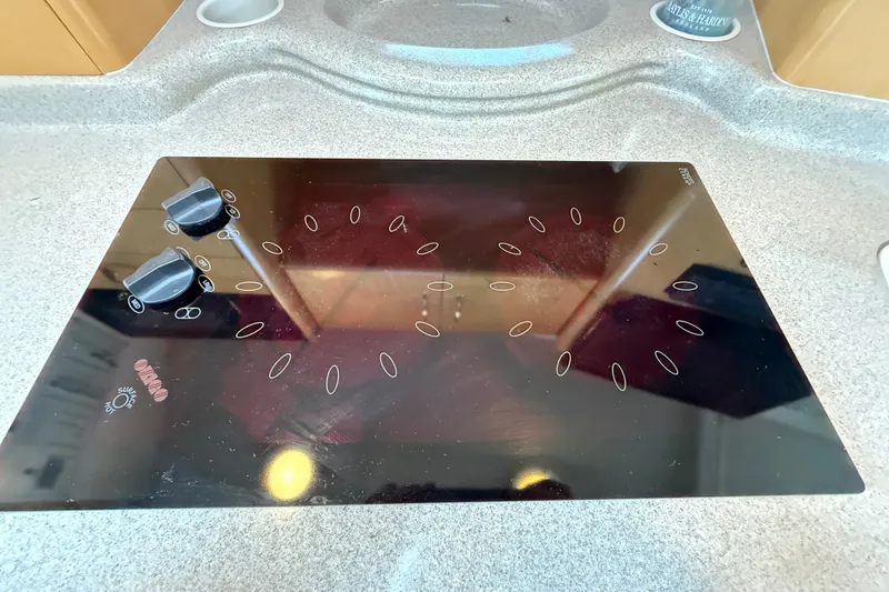 Slide: The Image of Glass cooktop on a 2000 Larson Cabrio 330 boat, featuring dual control knobs. - 35