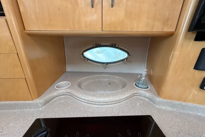 Slide: The Image of Interior of a 2000 Larson Cabrio 330 boat with countertop and porthole window. - 38