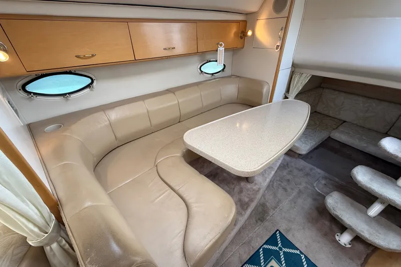 Slide: The Image of Interior of 2000 Larson Cabrio 330 boat with beige seating and oval table. - 32