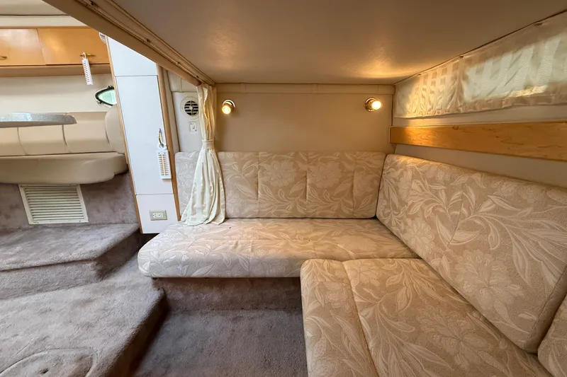 Slide: The Image of Interior of 2000 Larson Cabrio 330 boat with beige floral upholstery and cozy seating area. - 47