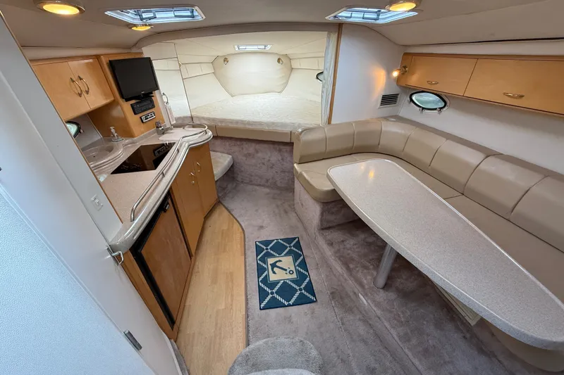 Slide: The Image of Interior of a 2000 Larson Cabrio 330 boat with kitchenette and seating area. - 29