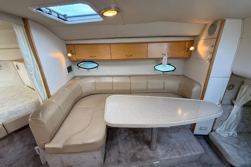 Slide: The Image of Interior of a 2000 Larson Cabrio 330 boat with beige seating and a table. - 31