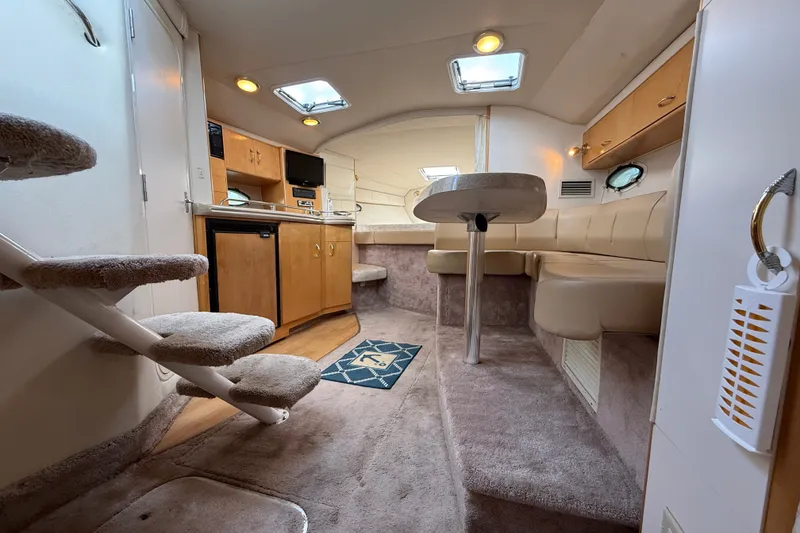 Slide: The Image of Interior of a 2000 Larson Cabrio 330 boat with cozy seating and kitchenette. - 48