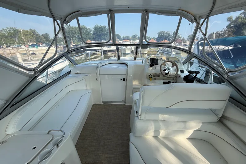 Slide: The Image of Interior of 2000 Larson Cabrio 330 boat with white seating and helm station. - 16