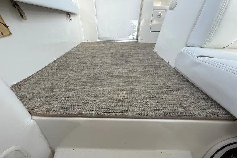 Slide: The Image of Interior view of a 2000 Larson Cabrio 330 boat with beige carpet flooring. - 18