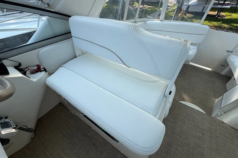 Slide: The Image of Interior of a 2000 Larson Cabrio 330 boat with white seating and beige flooring. - 21