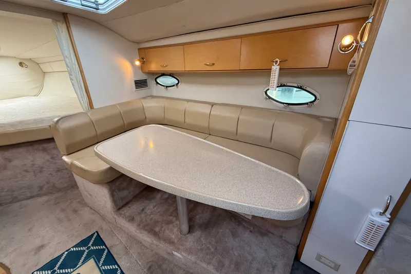 Slide: The Image of Interior of 2000 Larson Cabrio 330 boat with beige seating and oval table. - 30