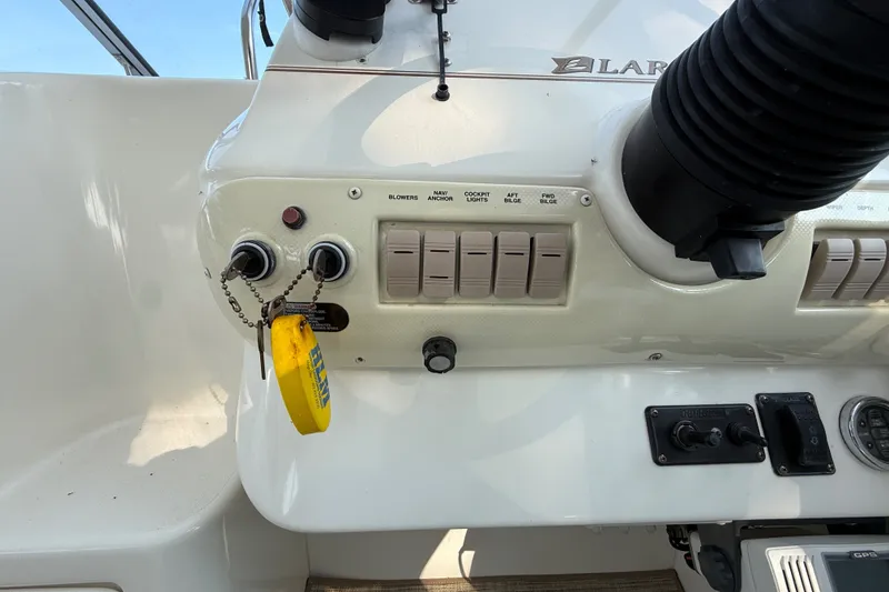 Slide: The Image of Control panel of a 2000 Larson Cabrio 330 boat with switches and keychain. - 23