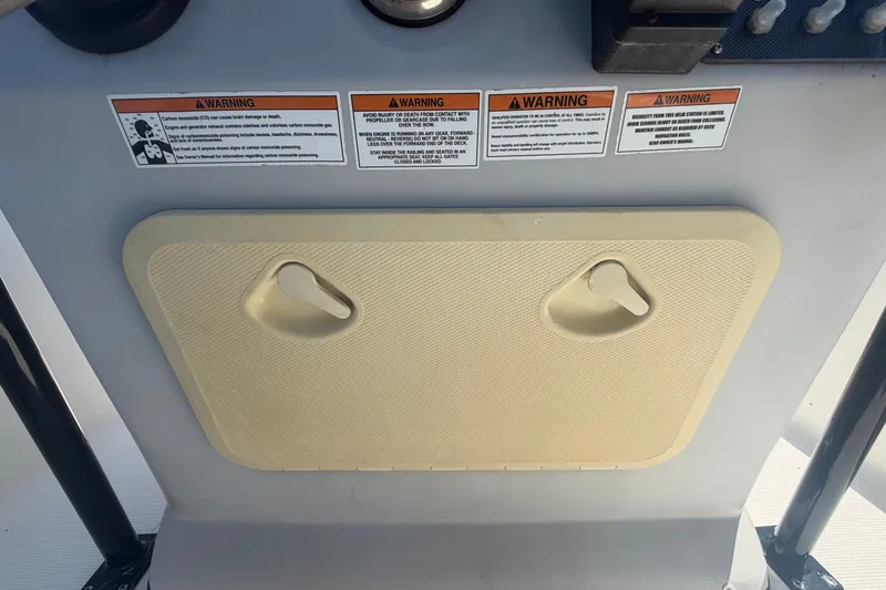 Slide: The Image of Control panel of 2022 Key Largo 180 Center Console with warning labels and hatch. - 23