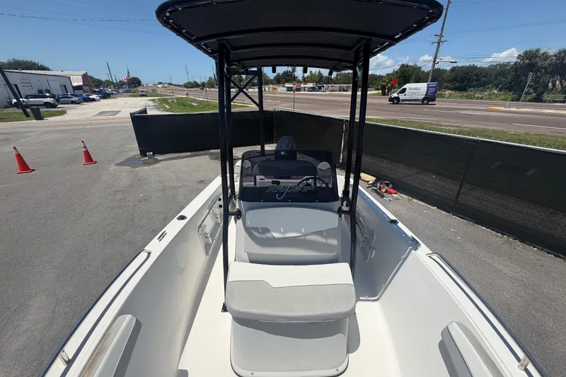 Slide: The Image of 2022 Key Largo 180 Center Console boat parked on pavement under clear sky. - 34