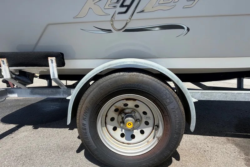 Slide: The Image of 2022 Key Largo 180 Center Console boat on trailer, showcasing wheel and fender detail. - 51