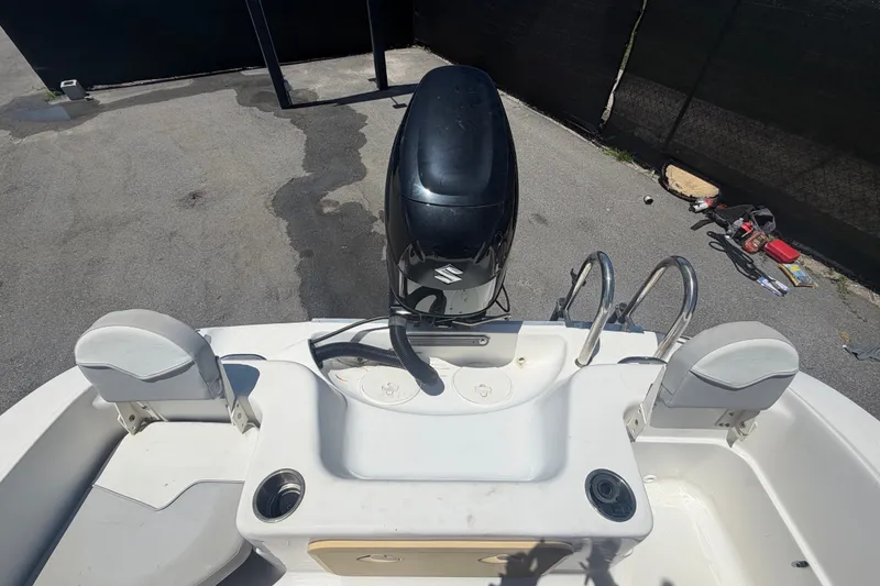 Slide: The Image of 2022 Key Largo 180 Center Console boat with Suzuki outboard motor, docked on pavement. - 48