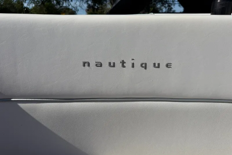 Slide: The Image of 2003 Nautique Air Nautique 226 interior detail with embossed logo on white upholstery. - 55