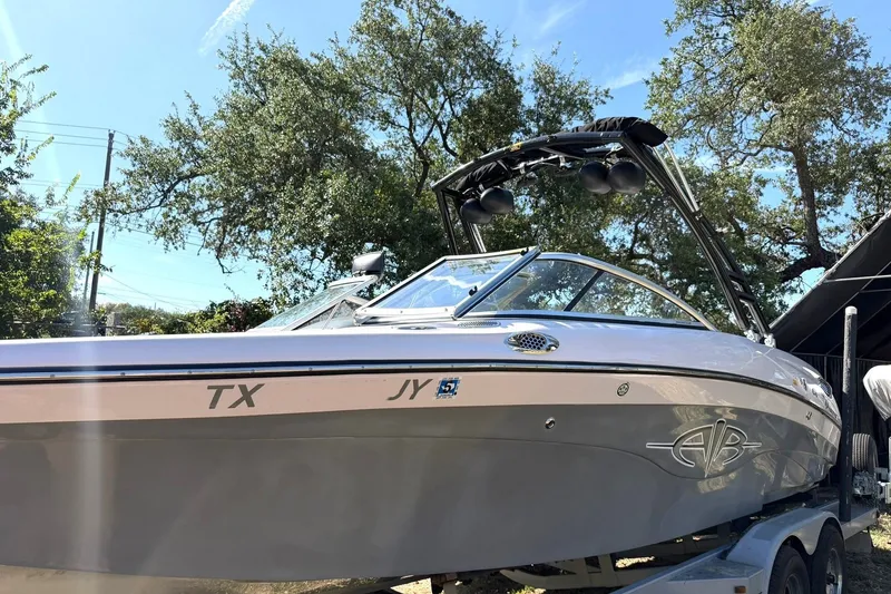 Slide: The Image of 2003 Nautique Air Nautique 226 boat on trailer, sunny day, trees in background. - 16