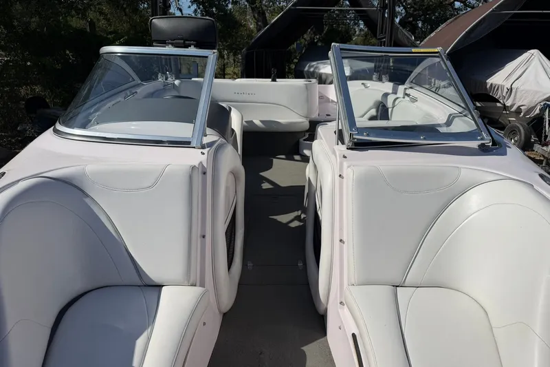 Slide: The Image of 2003 Nautique Air Nautique 226 boat interior with white seating and dual windshields. - 51