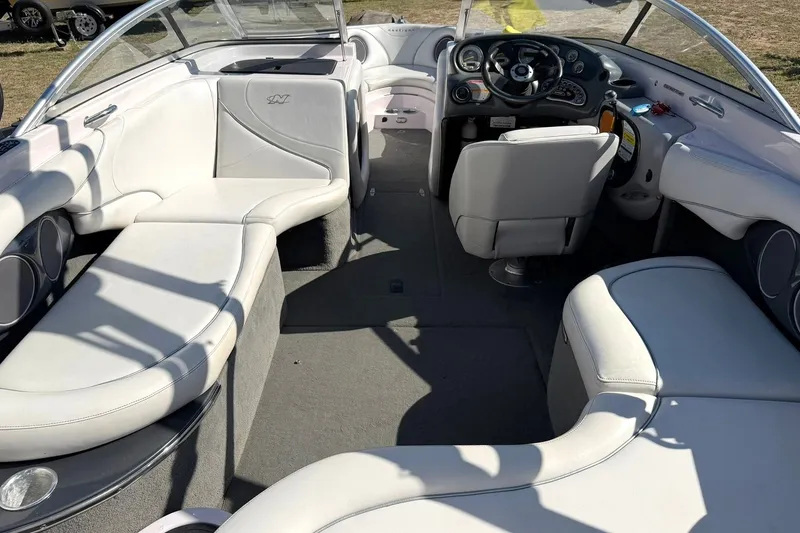 Slide: The Image of Interior of a 2003 Nautique Air Nautique 226 boat with white seating and modern dashboard. - 26