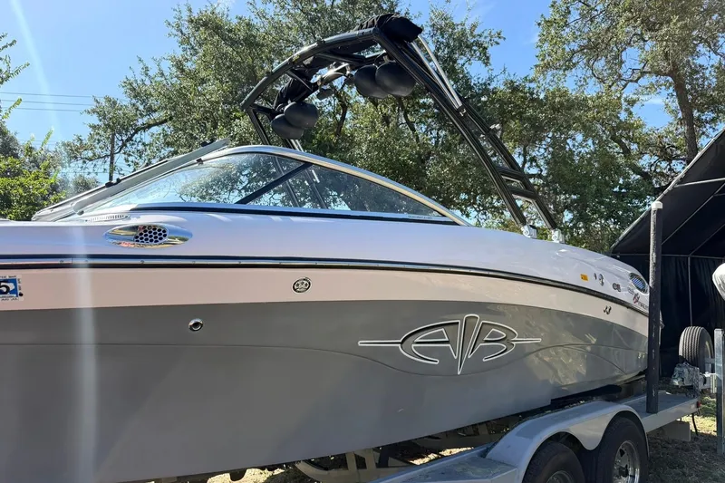 Slide: The Image of 2003 Nautique Air Nautique 226 boat on trailer, under sunny sky with trees in background. - 17